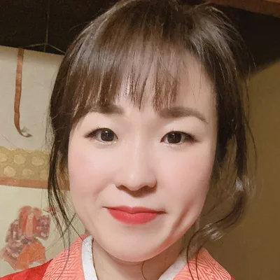 Portrait de l'hôte de KANAYA, en kimono rouge devant le tokonoma